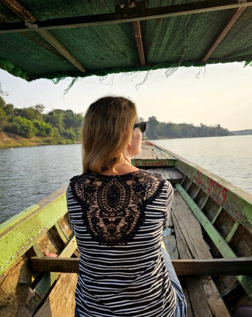 Simone sitzt in einem Boot und blickt auf einen ruhigen See.